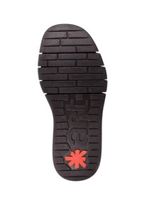 Suela de goma negra con un patrón texturizado, que presenta ranuras profundas y un logo de asterisco rojo en el talón. Diseño plano para mayor estabilidad.