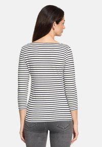 Gestreiftes Langarmshirt in Weiß und Marineblau, mit rundem Ausschnitt und taillierter Silhouette, aus einem glatten, dehnbaren Stoff gefertigt.