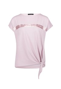 Jasnoróżowa bluzka z krótkim rękawem, z węzłem po boku i poziomym paskiem cekinowym na wysokości klatki piersiowej. Gładki materiał o luźnym fasonie.