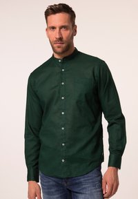 Groene langemou-shirt met een opstaand kraagje, voorzien van een voorzak en witte knopen, gemaakt van een gestructureerde stof.
