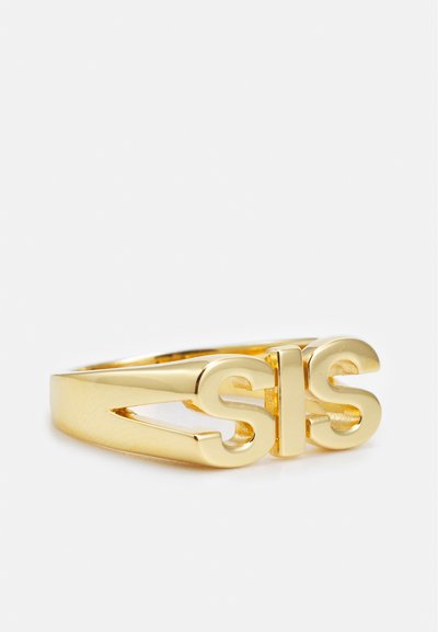 Zlatni metalni prsten sa izrezbarenom dizajnom u kojem se ističu slova "SIS". Glatka, polirana završna obrada s elegantnim siluetom.