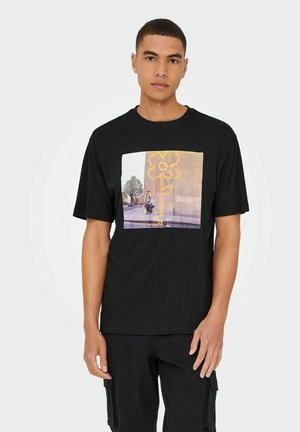 Sort bomuld t-shirt med et grafisktryk af en blomst og en person på en struktureret baggrund. Korte ærmer og afslappet pasform.