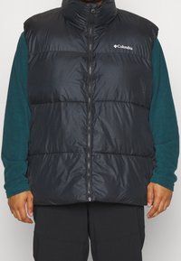 Chaleco acolchado negro con cuello alto, cremallera frontal y logo de Columbia. Diseño acolchado, hecho de material ligero y brillante.