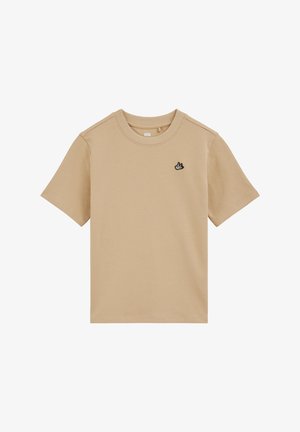 Beżowy t-shirt z krótkim rękawem i okrągłym dekoltem, z małym czarno-białym haftowanym logo ptaka na lewej piersi.