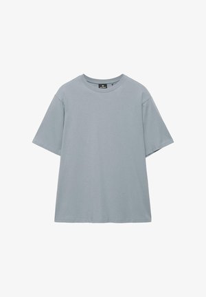 Obična svjetlosiva majica kratkih rukava s okruglim izrezom, ležernog kroja i vidljivim šavovima na rukavima i rubu.