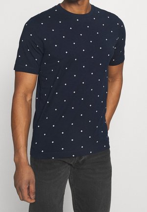 Navy blue short-sleeve t-shirt featuring a geometric diamond pattern in white. Made of soft fabric with a classic crew neck design.