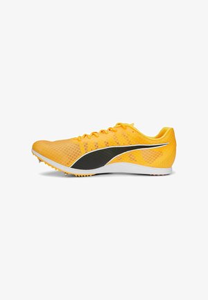 Chaussures de course jaunes avec un dessus en mesh, accents noirs et semelles acérées. Elles présentent un design épuré et une finition texturée pour une meilleure adhérence.