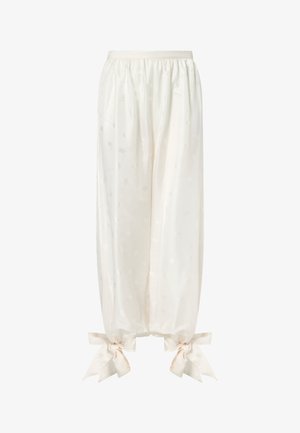 Locker sitzende Satinhosen aus Creme mit dezentem Blumenmuster und großen Schleifen, die an den Knöchelabschlüssen gebunden sind.