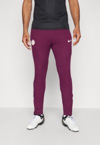 Bordo ribota sporta bikses ar baltu Nike logotipu un baltu emblemu augšējā augšstilbā. Izgatavotas no stiepjama, strukturēta materiāla.