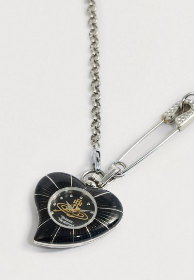 Sirds formas melns un sudraba kabatas pulkstenis ar kristāla stundas atzīmēm, pievienots ķēdītē pie drošības piespraudes.