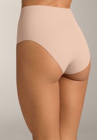 Biancheria intima beige a vita alta con una texture liscia senza cuciture, caratterizzata da un design a copertura totale e una forma posteriore curva.