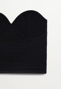 Top sans bretelles noir avec une texture côtelée et un décolleté structuré en cœur. Tissu lisse avec des lignes horizontales et verticales.