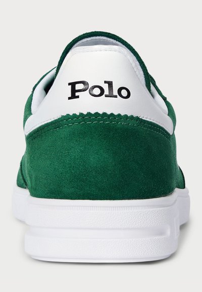 Zaļi zamša sporta apavi ar baltu ādas akcentu un melnu "Polo" logo uz papēža. Zole ir gumijas ar teksturētām gripu rakstu.