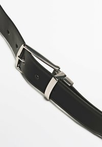 Schwarzer Leder Gürtel mit einer polierten silbernen Schnalle und mehreren Einstelllöchern, ausgestattet mit einer glatten Textur und einem eleganten Design.