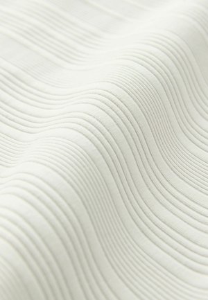 Texturiertes weißes Gewebe mit sanften, wellenförmigen Rippen. Jede Rippe ist gleichmäßig und schafft ein zartes, sich wiederholendes Muster auf der Oberfläche.