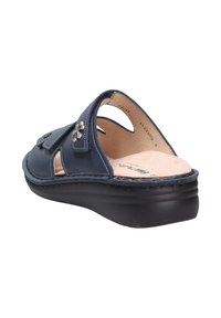 Navy blue leather sandal with a closed toe, cutouts, and a decorative silver flower. Features a cushioned insole and thick black sole.