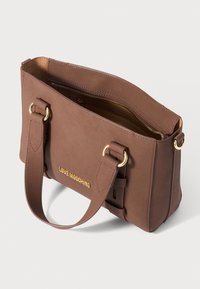 Ruda stačiakampė rankinė su dviem diržais, auksinis "Love Moschino" logotipas ir viršutinė užtrauktuko uždarymo sistema, kuri atskleidžia kreminės spalvos vidinį pamušalą.