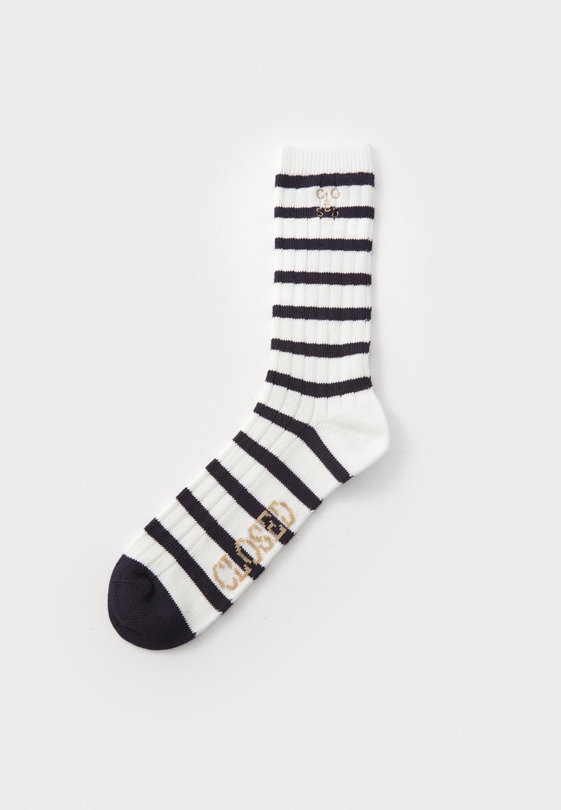 Striped socks in white and navy, featuring a ribbed texture. "CLOSED" embroidered in gold on the side. Rounded toe and dark heel.