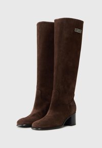 Stivali al ginocchio in suede marrone con punta quadrata, tacco a blocco basso e dettaglio di cut-out laterale, dotati di una targhetta con logo sullo stivale esterno.