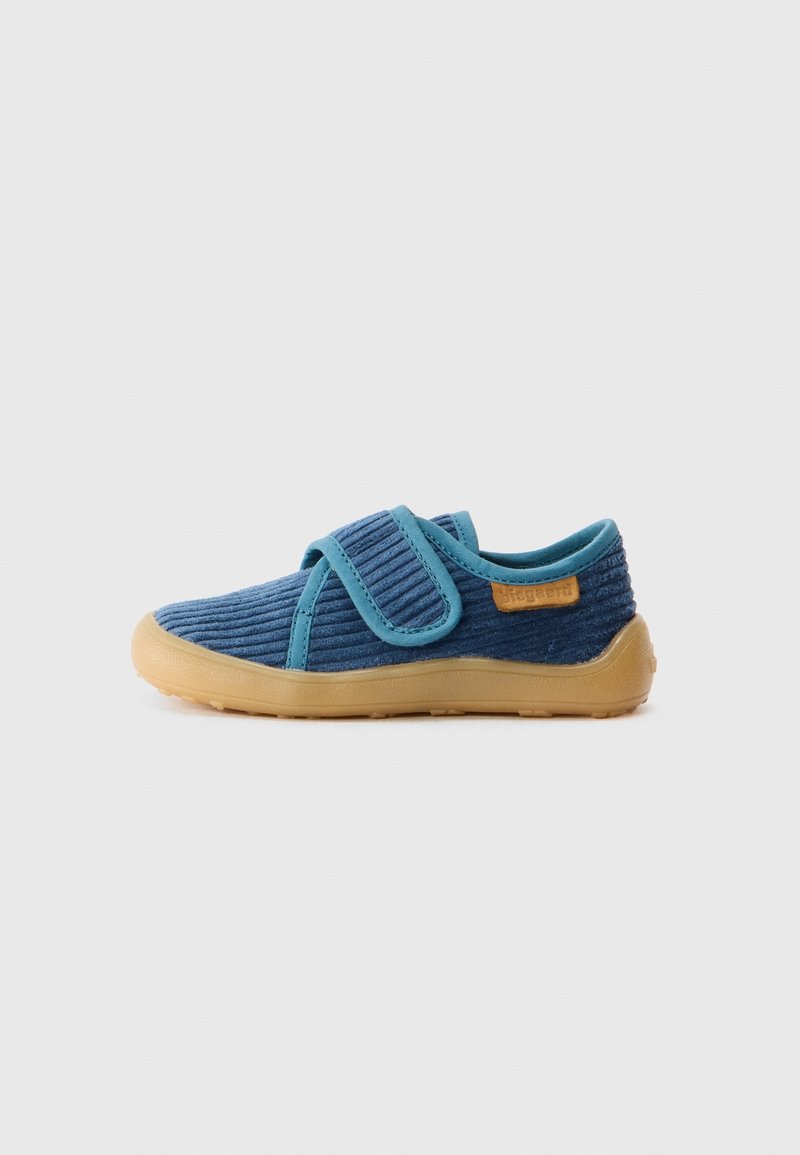 Chaussure enfant en velours côtelé bleu avec semelle en caoutchouc beige et une seule bride Velcro, vue de côté sur un fond uni.