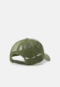 Zöld hálós baseball sapka, szilárd elülső részel és hajlított napszemüveggel. Hátsó állítható pánt a megfelelő illeszkedésért. Texturált anyag ventilációs lyukakkal.
