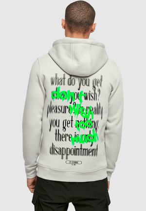 Light gray hoodie featuring large black text with green accents on the back, displaying a fragmented message. Made of soft fabric.