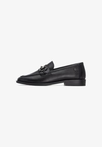 Mocasines de cuero negro con puntera redondeada, que cuentan con una hebilla decorativa y un tacón bajo. Textura lisa con detalles de costura mínimos.