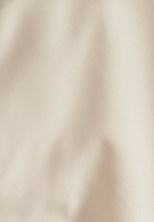 Tissu beige texturé avec un motif fin, texture douce et léger éclat. Le matériau semble léger et flexible, adapté à diverses applications.