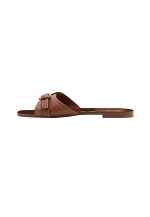 Brun læder flad slip-sandal med en bred rem med hvid syning og en dekorativ spænde på en hvid baggrund.