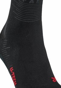 Czarna skarpetka sportowa wykonana z teksturowanego materiału z prążkowanym wzorem. Posiada czerwony detal z logo oraz kontrastowy kolor w obszarze palców.