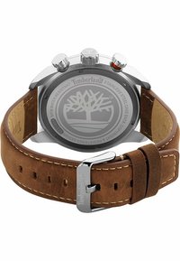 Brauner Lederarmband mit Edelstahlakzenten, rundem Zifferblatt und Timberland-Logo auf der Gehäuserückseite. Wasserdicht bis 5 ATM.