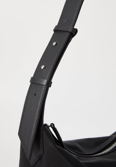 Black fabric handbag featuring a wide adjustable leather strap with silver hardware and a smooth finish, showcasing sleek design and minimal details.