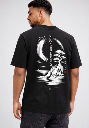 Man wearing black T-shirt with white graphic of stylized moon, birds, tree on rocky island, vertical text "NEVERLESS" and small Japanese characters.