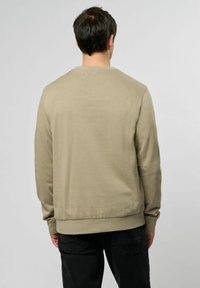 Felpa beige con maniche lunghe, scollo rotondo e polsini a costine. Realizzata in materiale morbido, presenta una texture liscia e una vestibilità comoda.
