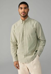 Lichtgroen, langarm shirt met een button-down kraag, é�én borstzak en een rechte zoom. Glad textuur met een ontspannen pasvorm.