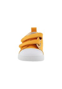 Zapato de lona amarillo con tres tiras de Velcro, puntera de goma blanca y suela blanca texturizada. Presenta un lazo trasero para facilitar su colocación.