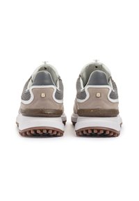 Sneakers con tomaia in mesh grigia, dettagli in suede beige, un'imbracatura bianca e una suola in gomma marrone testurizzata. Vista posteriore, dettagli di branding minimi.