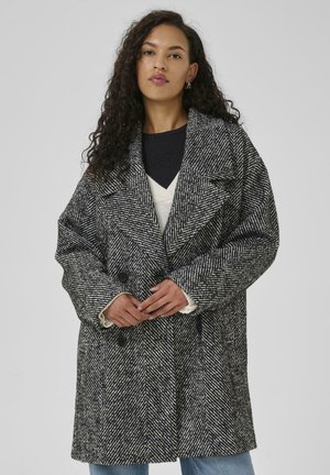 Jacke im Karomuster in Schwarz und Weiß, mit einem doppelten Knopfverschluss, breiten Revers und strukturierter Stoffoberfläche mit großen Knöpfen.