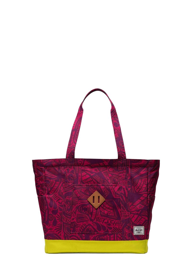 Sac fourre-tout à motifs violets avec une base jaune, comportant deux poignées en tissu et un accent en cuir brun en forme de diamant sur le devant.