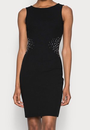 Robe noire sans manches à silhouette ajustée, ornée de pierres claires à la taille, en tissu lisse, avec un col rond.