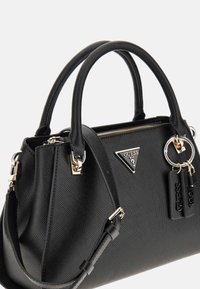 Black handbag with textured material, dual handles, adjustable strap, gold-tone hardware, and brand logo on front.