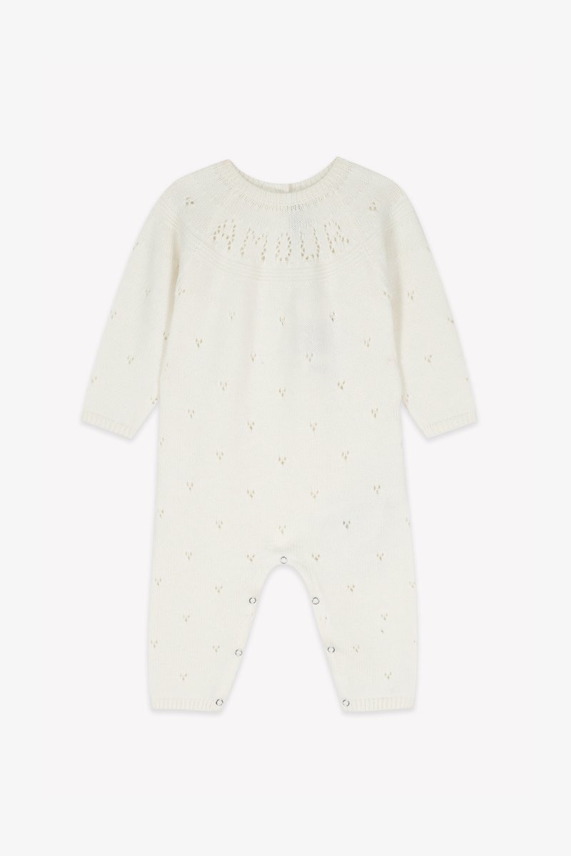 White knitted romper with long sleeves, textured pattern, and tiny heart motifs. Features snap closures at the bottom for easy dressing.