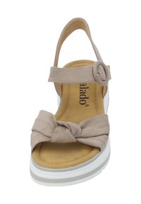 Sándalo de ante beige con tirante frontal anudado, correa en el tobillo ajustable y suela de plataforma blanca. Textura suave y diseño casual.