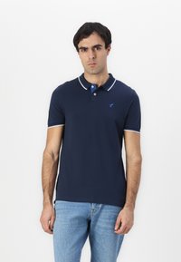 Navy blue polo shirt made of cotton, featuring a classic collar with light blue trim, short sleeves, and a small logo on the chest.