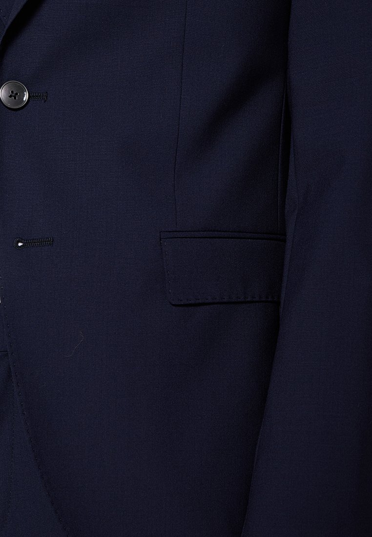 Dunkelblaues Sakko mit Knopf, Knopfloch und Klappentasche auf der rechten Seite.
