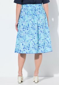 Gonna floreale blu con elastico in vita, taglio a ginocchio, con uno sfondo azzurro chiaro e dettagliati motivi botanici.