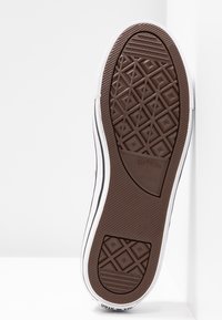 Braune Gummi-Außensohle mit einem strukturierten Diamantmuster, weißem Kantenabschluss und sichtbarem "Converse All Star"-Markenlogo.