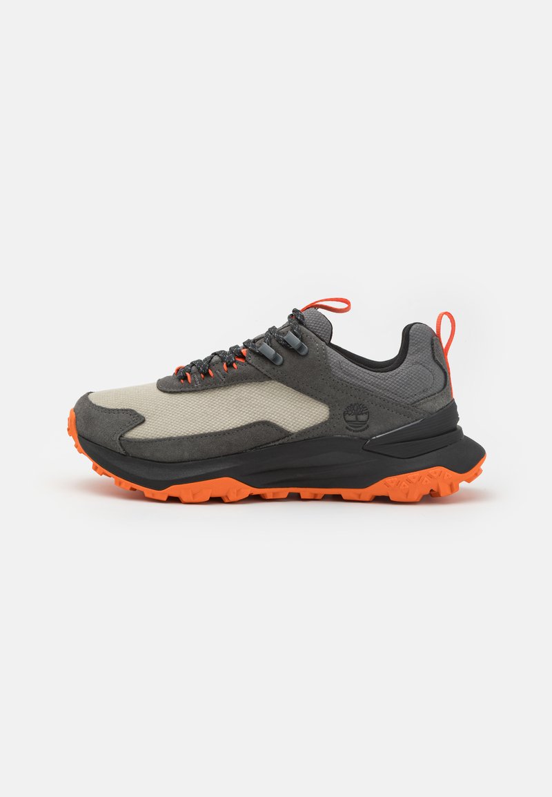 Gray and black athletic shoe with a textured upper, orange outsole, and accents. Features grey mesh, black rubber sole, and orange laces.