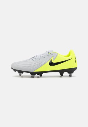 Chaussure de football Nike Phantom grise et jaune néon avec logo Swoosh noir et crampons métalliques sur semelle noire, vue de profil sur fond blanc.