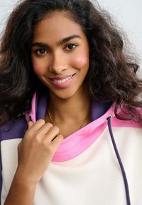 Bluza z kapturem w kolorach różowym i fioletowym, wykonana z miękkiego materiału, z regulowanymi sznurkami i luźnym krojem.